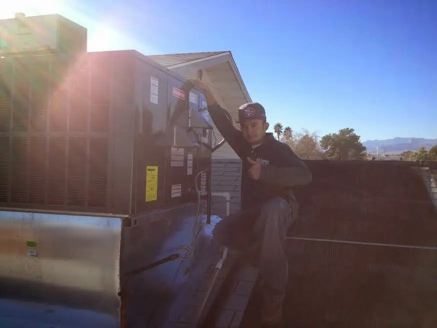 HVAC technician performing HVAC Inspection on a rooftop unit in Lancaster